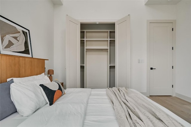 2209 Woodland Ave Unit 501, Austin, TX 78741 - bedroom featuring wood finished floors, a closet, and baseboards