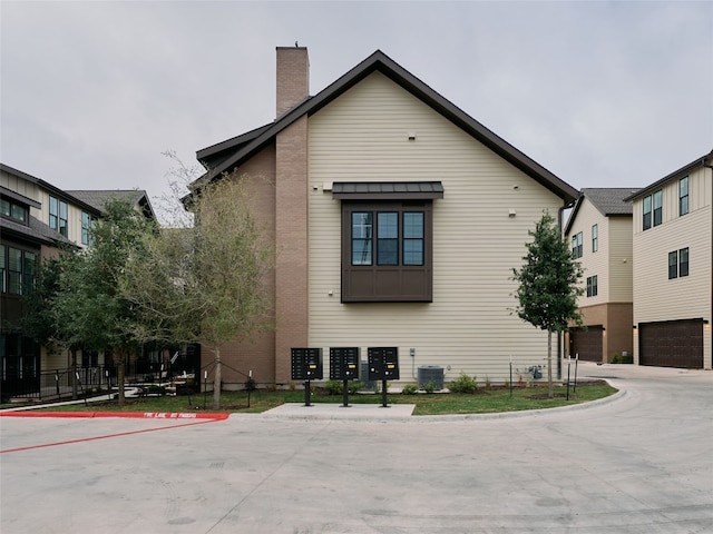 2209 Woodland Ave Unit 501, Austin, TX 78741 - view of home's exterior with mail area, a chimney, and central air condition unit