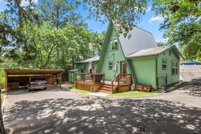 113 S Kanaio Dr, Bastrop, TX 78602 - a-frame style home featuring asphalt driveway, metal roof, and a wooden deck