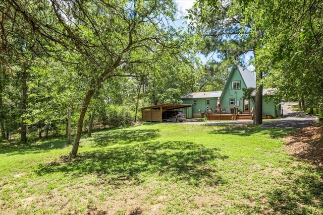 113 S Kanaio Dr, Bastrop, TX 78602 - view of grassy yard featuring a detached carport and a wooden deck