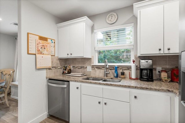 113 S Kanaio Dr, Bastrop, TX 78602 - kitchen featuring stainless steel dishwasher, a sink, decorative backsplash, and white cabinets