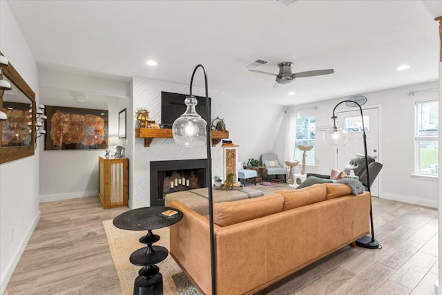 113 S Kanaio Dr, Bastrop, TX 78602 - living room with light wood finished floors, baseboards, a fireplace, a ceiling fan, and recessed lighting