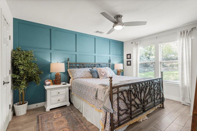 113 S Kanaio Dr, Bastrop, TX 78602 - bedroom with a decorative wall, wood finished floors, baseboards, and ceiling fan
