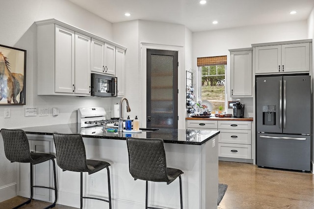 9750-9800 Ledgestone Ter, Austin, TX 78737 - kitchen featuring stainless steel fridge, black microwave, a peninsula, recessed lighting, and a sink