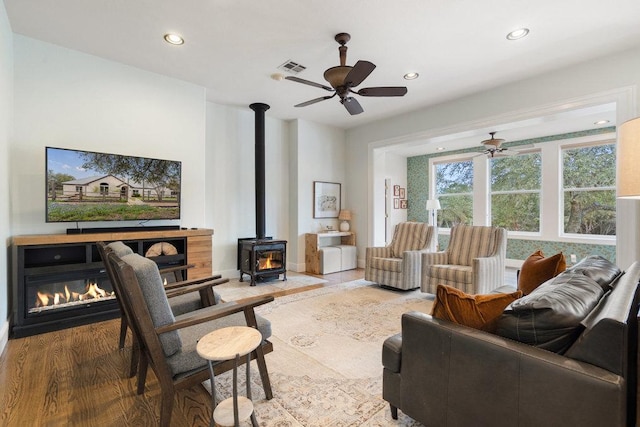 9750-9800 Ledgestone Ter, Austin, TX 78737 - living area with ceiling fan, a wood stove, recessed lighting, wood finished floors, and baseboards
