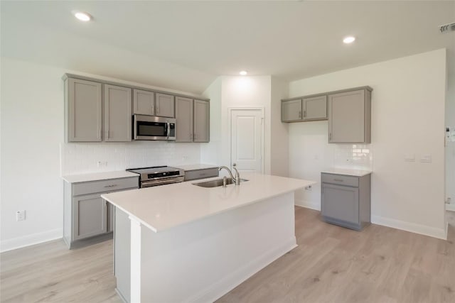 513 Tekoa Dr, Georgetown, TX 78628 - kitchen featuring gray cabinets, stainless steel appliances, a sink, light wood finished floors, and recessed lighting