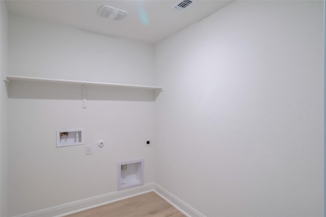 513 Tekoa Dr, Georgetown, TX 78628 - washroom featuring gas dryer hookup, light wood finished floors, hookup for an electric dryer, hookup for a washing machine, and baseboards