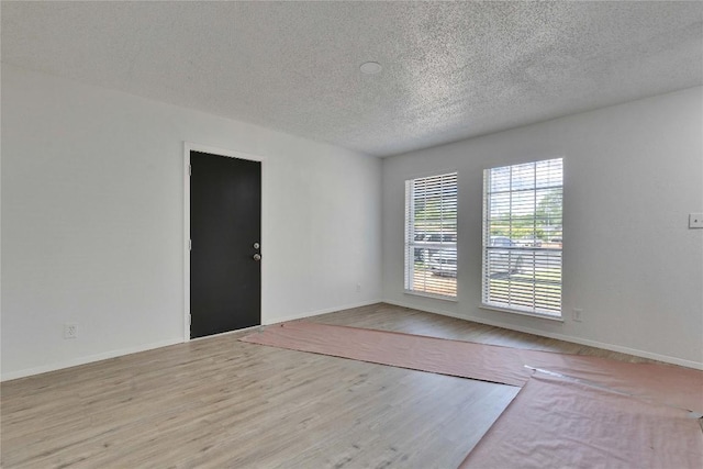 4504 Little Hill Cir, Austin, TX 78725 - spare room featuring a textured ceiling, baseboards, and wood finished floors