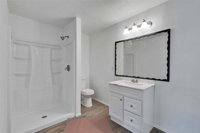 4504 Little Hill Cir, Austin, TX 78725 - bathroom with wood finished floors, a shower, toilet, vanity, and a textured ceiling