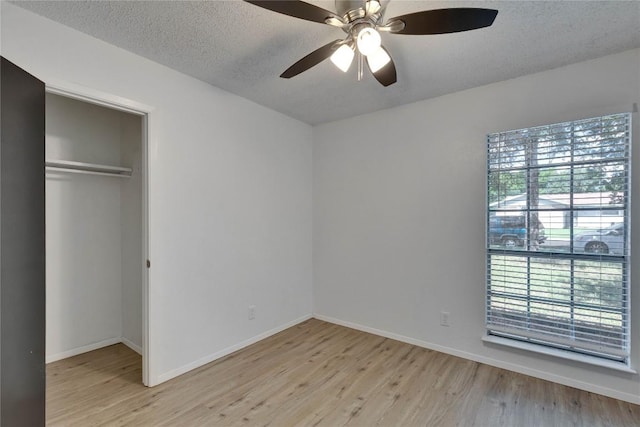 4504 Little Hill Cir, Austin, TX 78725 - unfurnished bedroom with light wood finished floors, baseboards, a closet, and a textured ceiling