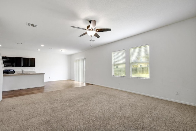 750 Bunton Reserve Blvd, Kyle, TX 78640 - unfurnished living room featuring light colored carpet, a ceiling fan, and recessed lighting