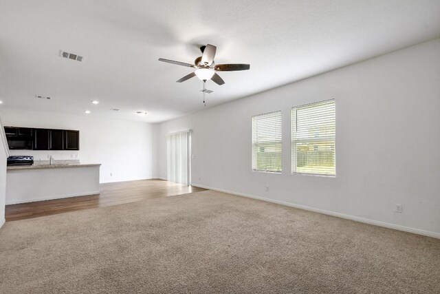 750 Bunton Reserve Blvd, Kyle, TX 78640 - unfurnished living room featuring light colored carpet, a ceiling fan, and recessed lighting