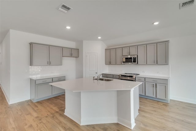 537 Tekoa Dr, Georgetown, TX 78628 - kitchen featuring gray cabinets, stainless steel appliances, decorative backsplash, an island with sink, and recessed lighting