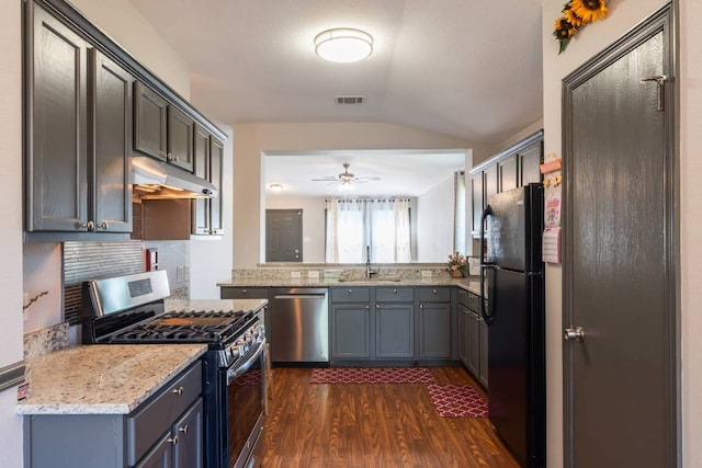 404 Paige Bnd, Hutto, TX 78634 - kitchen with appliances with stainless steel finishes, under cabinet range hood, vaulted ceiling, dark wood-style floors, and a ceiling fan