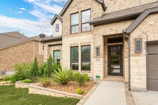 doorway to property featuring stone siding and brick siding