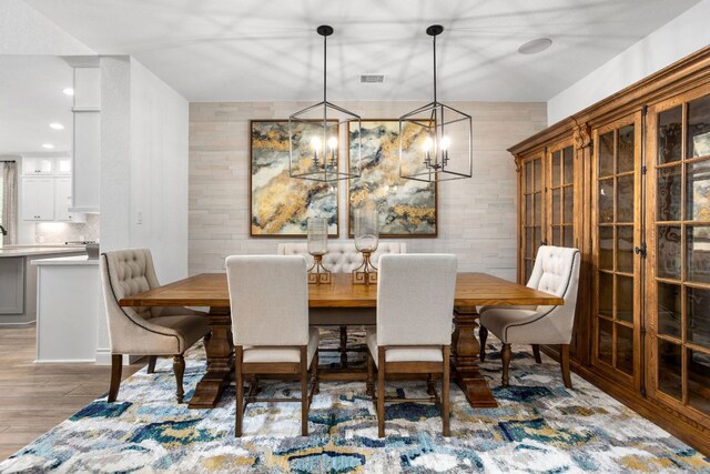 dining space featuring wood finished floors and a chandelier