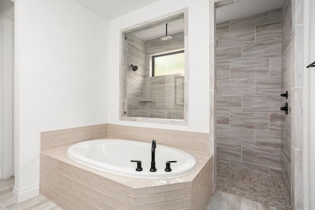 full bath with a tile shower and a bath