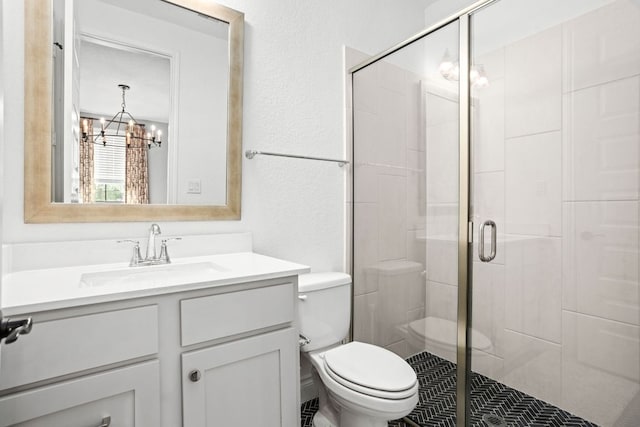full bathroom with a chandelier, vanity, toilet, and a stall shower