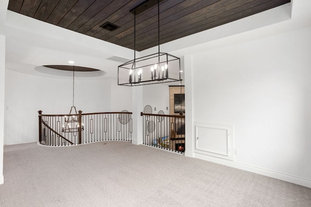 unfurnished room featuring a chandelier, carpet flooring, and wood ceiling