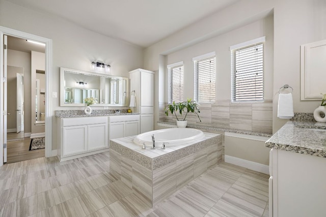 19312 Abigail Way, Pflugerville, TX 78660 - bathroom featuring a garden tub, vanity, tile patterned flooring, and baseboards