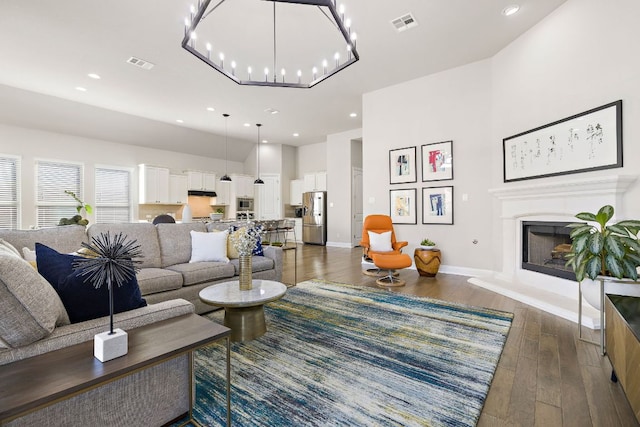 19312 Abigail Way, Pflugerville, TX 78660 - living area with wood finished floors, a fireplace with raised hearth, baseboards, recessed lighting, and a towering ceiling