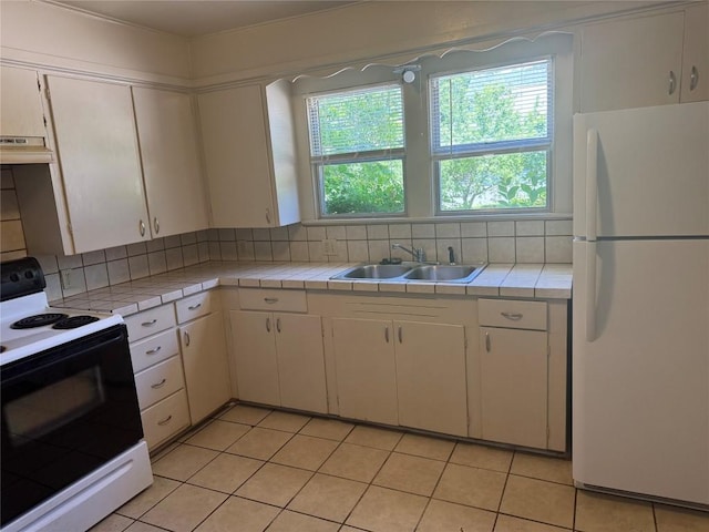 1711 Singleton Ave, Austin, TX 78702 - kitchen with white appliances, tile countertops, a sink, and decorative backsplash