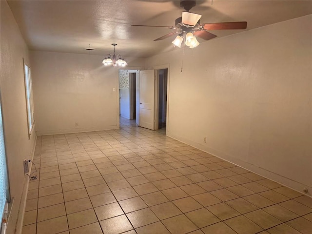 1711 Singleton Ave, Austin, TX 78702 - unfurnished room with a ceiling fan, light tile patterned flooring, a chandelier, and baseboards