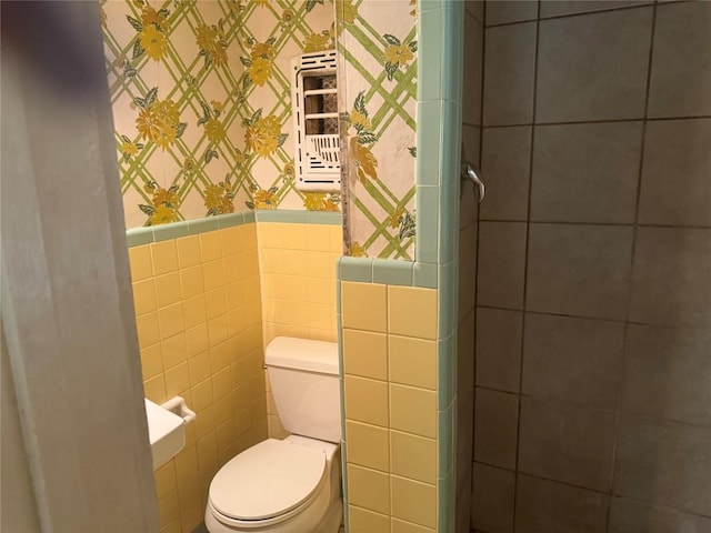 1711 Singleton Ave, Austin, TX 78702 - bathroom featuring wallpapered walls, toilet, a wainscoted wall, and tile walls