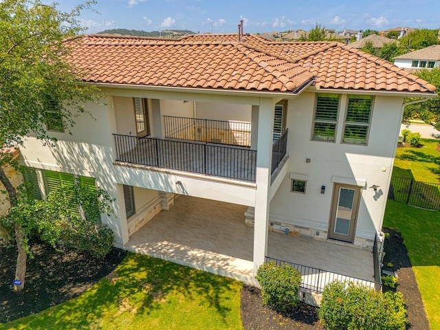406 Woodside Ter, Austin, TX 78738 - rear view of house featuring a balcony, a patio, stucco siding, and a tiled roof