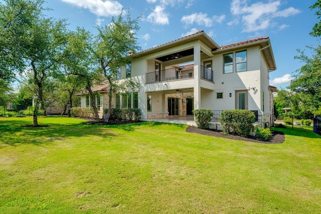 rear view of house with a balcony, a ceiling fan, stucco siding, and a tiled roof