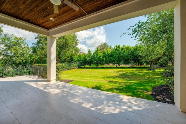 view of patio / terrace featuring a ceiling fan and view of wooded area