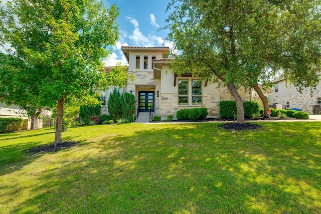 view of front of home with french doors, stone siding, a front yard, and a tiled roof