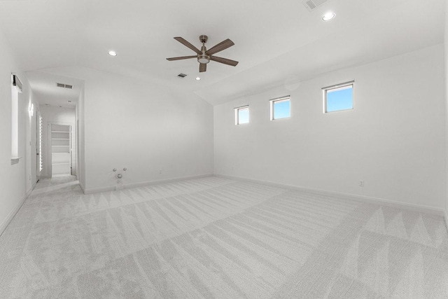 spare room featuring light colored carpet, vaulted ceiling, baseboards, a ceiling fan, and recessed lighting