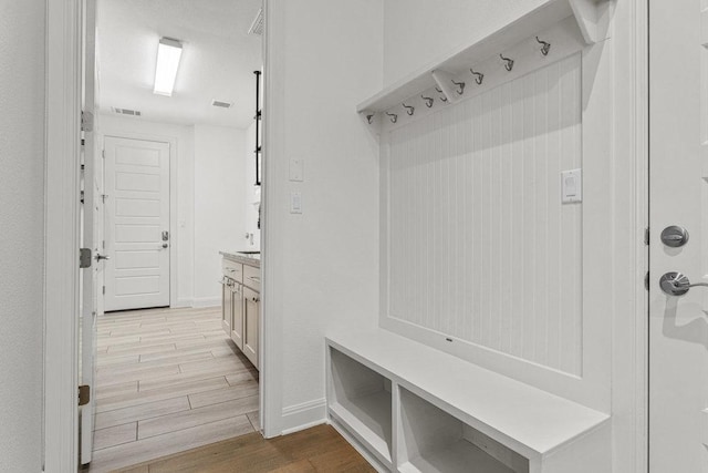 mudroom with light wood-style floors and baseboards