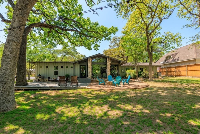 202 Tanglewood Dr, Fredericksburg, TX 78624 - back of property with board and batten siding and a wooden deck