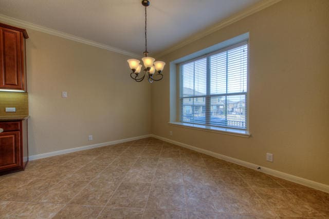 empty room with ornamental molding, a chandelier, baseboards, and light tile patterned flooring