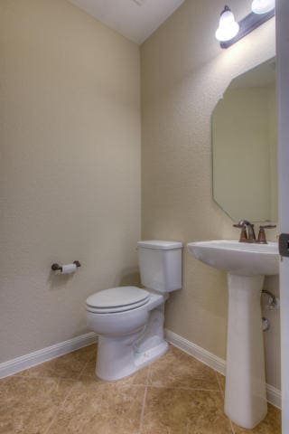 bathroom featuring toilet and baseboards