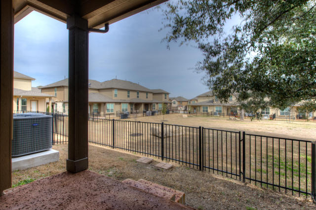 fenced backyard with central AC and a residential view