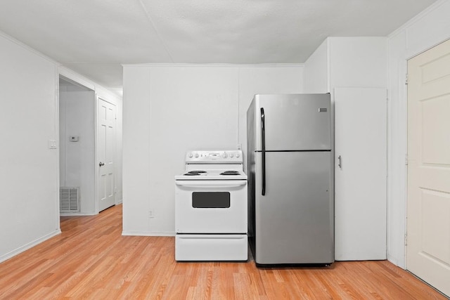 201 N Bowie Ave, Cameron, TX 76520 - kitchen with freestanding refrigerator, white electric range, and light wood-style flooring
