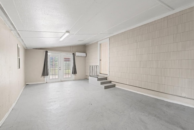 201 N Bowie Ave, Cameron, TX 76520 - unfurnished room with concrete flooring, french doors, a wall mounted air conditioner, and baseboards