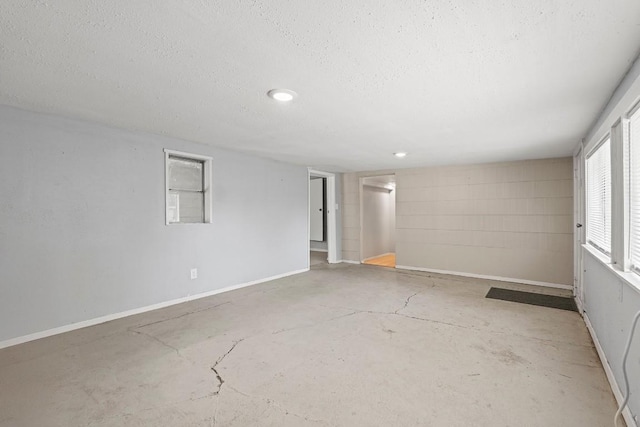 201 N Bowie Ave, Cameron, TX 76520 - empty room with concrete floors, a textured ceiling, and baseboards
