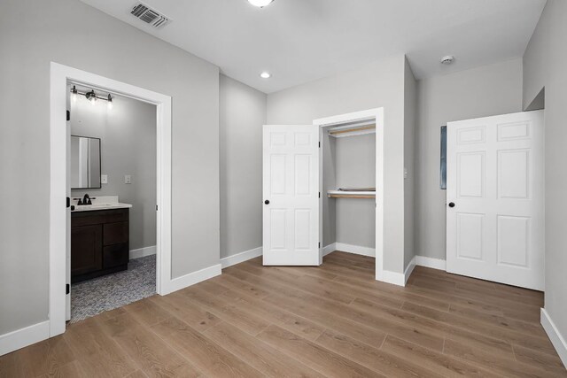 12935 Prairie Cir Unit 3641, Kempner, TX 76539 - unfurnished bedroom featuring light wood-type flooring, baseboards, a sink, connected bathroom, and a closet