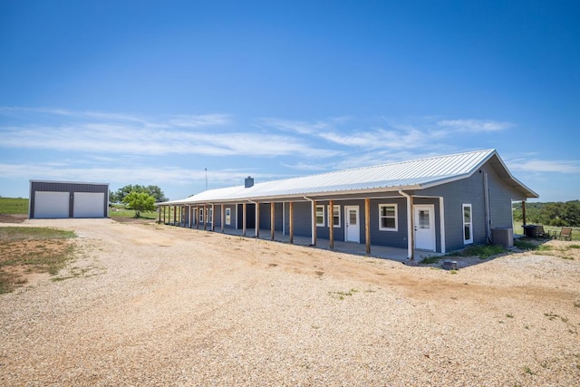 12935 Prairie Cir Unit 3641, Kempner, TX 76539 - view of front facade featuring a detached garage, metal roof, dirt driveway, central air condition unit, and covered porch