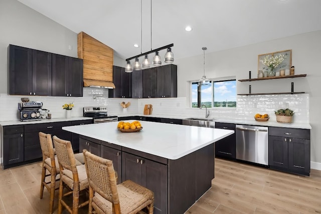 12935 Prairie Cir Unit 3641, Kempner, TX 76539 - kitchen featuring appliances with stainless steel finishes, light countertops, light wood finished floors, tasteful backsplash, and a sink