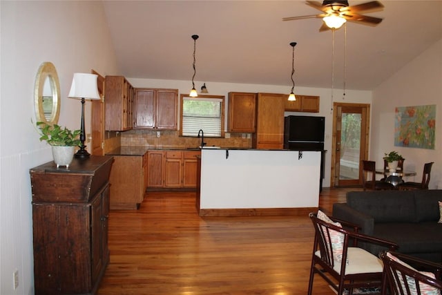 704 Marquis Ln, Cedar Park, TX 78613 - kitchen with lofted ceiling, wood finished floors, ceiling fan, backsplash, and a kitchen island