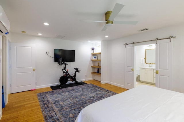 4902 Pony Chase, Austin, TX 78727 - bedroom with a barn door, light wood-style flooring, recessed lighting, ceiling fan, and a wall unit AC