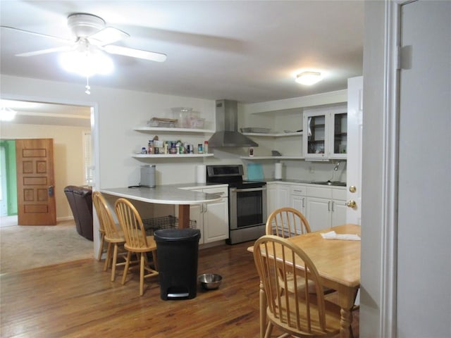 163 Cricket St, Tow, TX 78672 - kitchen featuring stainless steel range with electric cooktop, wall chimney range hood, open shelves, a sink, and white cabinetry