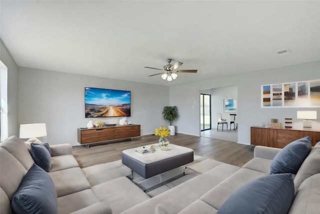 living room featuring light wood finished floors and a ceiling fan