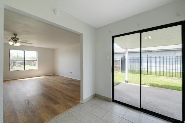 spare room with baseboards, a ceiling fan, light tile patterned flooring, and a smoke detector
