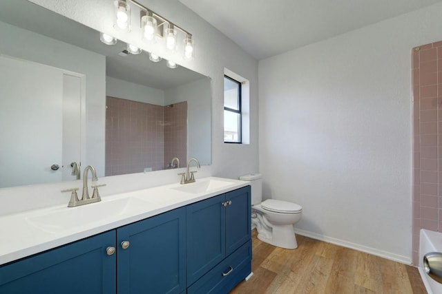 bathroom with wood finished floors, toilet, a tub to relax in, a shower, and double vanity
